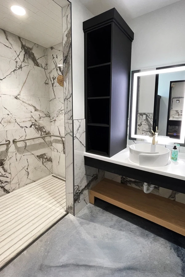 Marble, black millwork, and illuminated mirror at Central Wellness